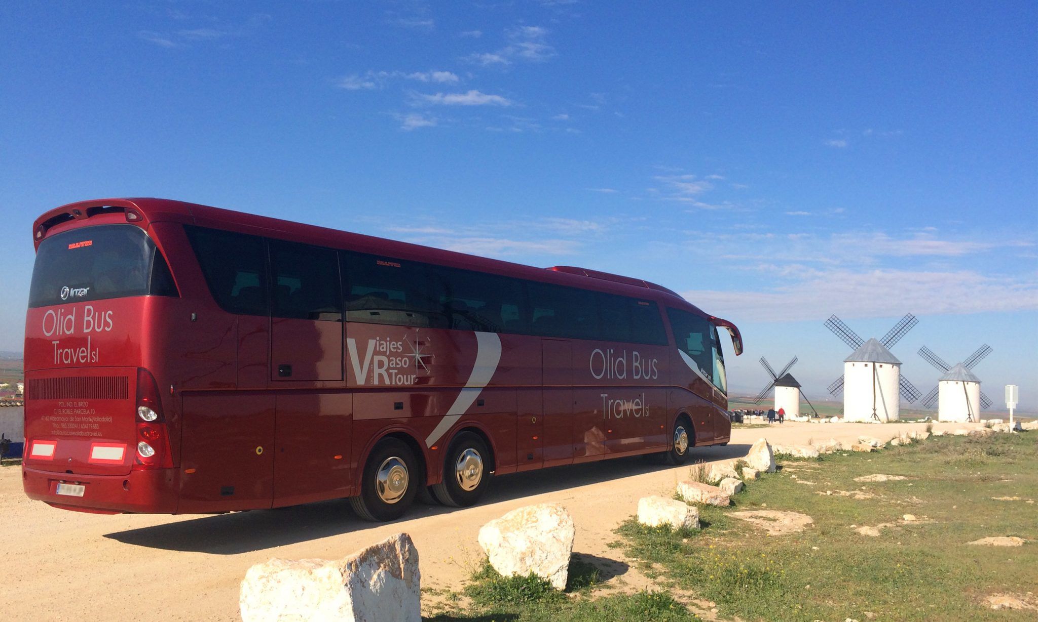 Autocar con 64 plazas de la empresa de autocares Olid Bus Travel de Valladolid junto a molinos de viento