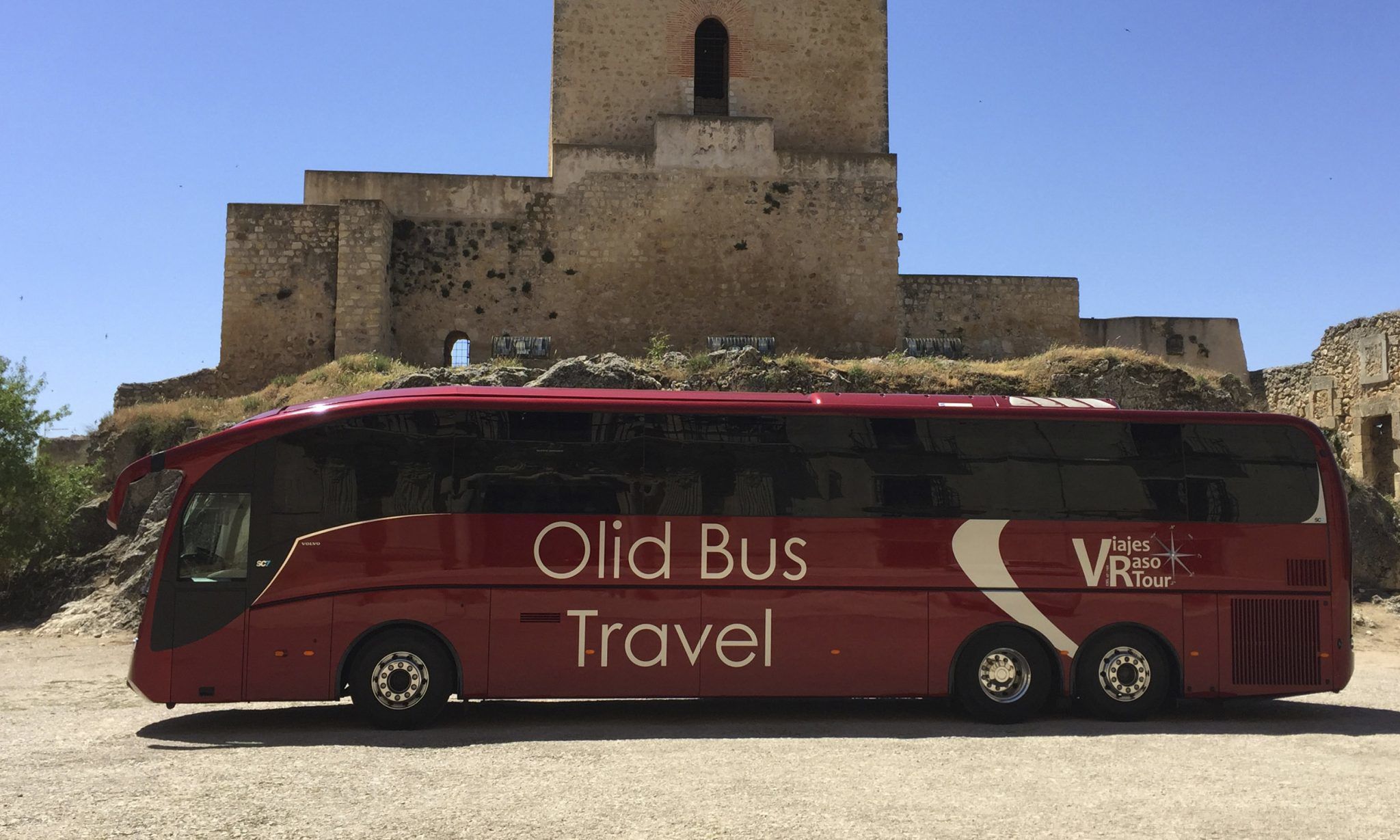 Autocar con 60 plazas de la empresa de autocares Olid Bus Travel de Valladolid frente a castillo